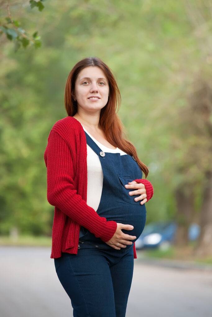 pregnant woman on summer alley